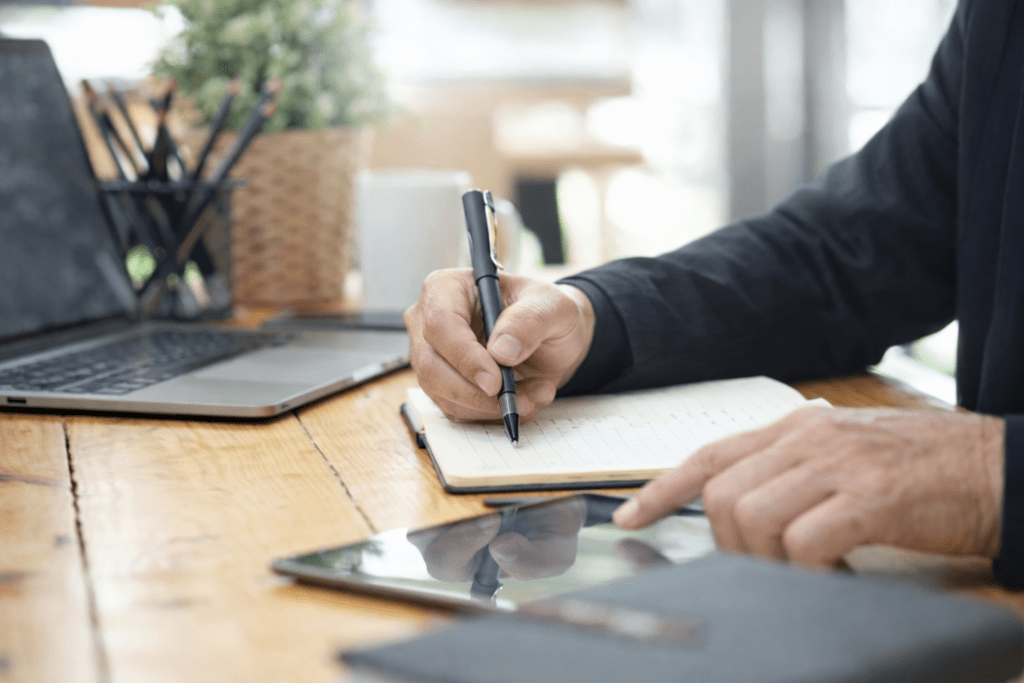 Person writing notes on paper at a desk